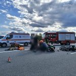 motociclist doar pe asfalt si motocicleta distrusa complet dupa o coliziune cu o masina