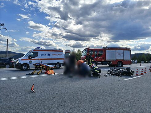 motociclist doar pe asfalt si motocicleta distrusa complet dupa o coliziune cu o masina
